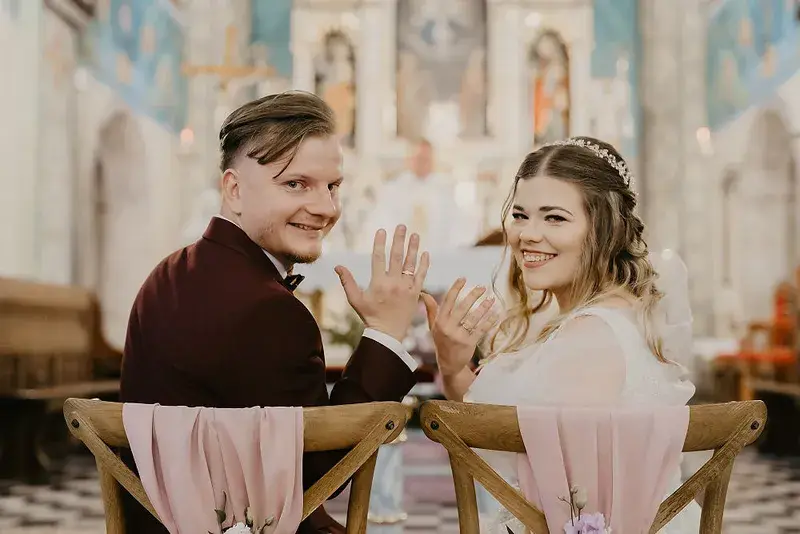 Para młoda odwracająca się do obiektywu podczas ceremonii w kościele Para młoda odwracająca się do obiektywu podczas ceremonii w kościele